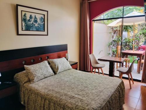 a bedroom with a bed and a table with chairs at Tambo II Hotel Campestre in Cieneguilla
