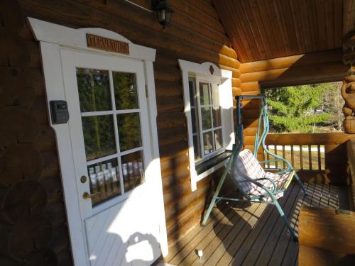 a rocking chair on the front porch of a cabin at Cottage-karaoke Koivikko in Äänekoski