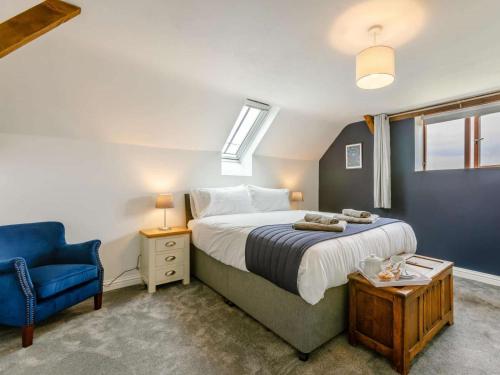 a bedroom with a bed and a blue chair at 2 Bed in Pershore oc-83007 in Eckington