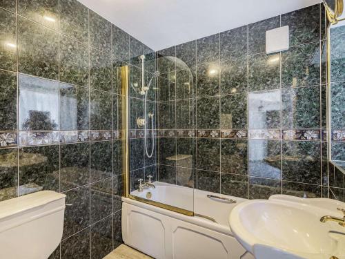 a bathroom with a tub and a toilet and a sink at 4 Bed in Skipton oc-89095 in Starbotton