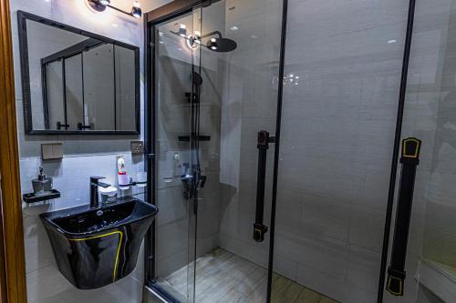 a bathroom with a glass shower and a sink at The Crest Apartment in Kigali