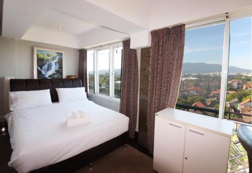 1 dormitorio con cama y ventana grande en Penthouse Galare Thong Tower, en Chiang Mai