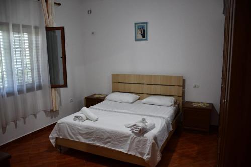 a bedroom with a bed with towels on it at Vila Rrozhani in Mabë