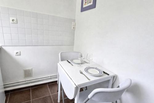 a small white table and chairs in a room at 5 Mins to Train Station - Free Parking - DisneyLand - Escapade Perchée in Pomponne