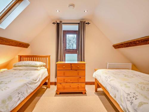 a attic bedroom with two beds and a window at 2 Bed in Wareham oc-dc184 in Stoborough