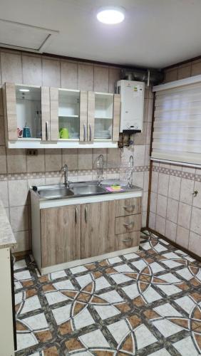 a kitchen with a sink and a tiled floor at Cabaña La Petita in Cherquenco