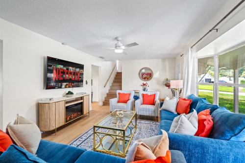 a living room with blue couches and a tv at Your own 5BR Private Oasis! wPrivate PoolPickleball in West Palm Beach