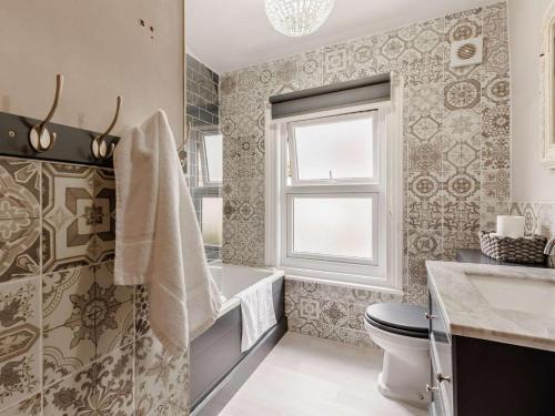 a bathroom with a tub and a toilet and a sink at 5 Bed in Pershore oc-91349 in Peopleton