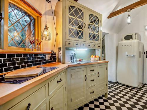 een keuken met witte kasten en een witte koelkast bij 2 Bed in Wareham oc-79305 in East Stoke