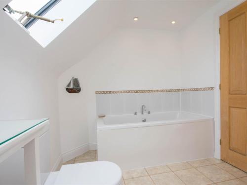 a white bathroom with a tub and a sink at 3 Bed in Wareham oc-dc137 in West Lulworth