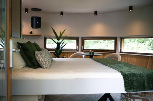 a bedroom with a large white bed with green pillows at Recreatiepark Den Blanken in Neede