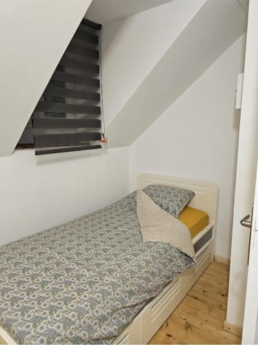 a small bed in a small room with a window at Villa chez Fred in Le Quesnoy