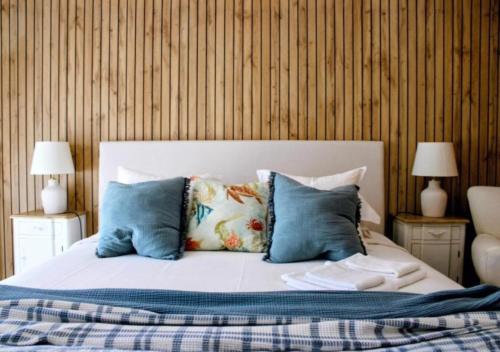 a bedroom with a bed with blue and white pillows at Casa by Anita Guesthouse in Esposende