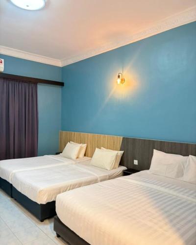 two beds in a room with blue walls at SURIA BEACH RESORT Pangkor in Pangkor