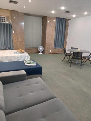 a room with a bed and a table and chairs at Apto Candelária in Rio de Janeiro