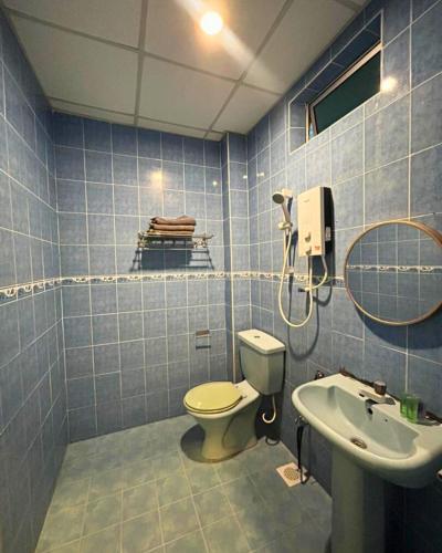 a blue tiled bathroom with a toilet and a sink at SURIA BEACH RESORT Pangkor in Pangkor