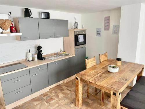 a kitchen with a wooden table and a kitchen with a counter at Ferienwohnung Kleinôd Sayn in Bendorf