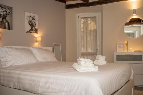 a bedroom with a white bed with towels on it at Ledy Apartment in Lovere