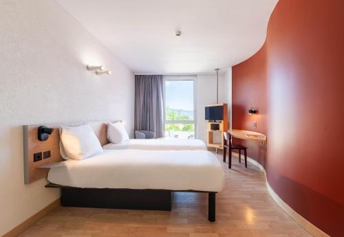 une chambre d'hôtel avec un grand lit et une fenêtre dans l'établissement B&B HOTEL Lully 3 Lakes, à Estavayer-le-Lac