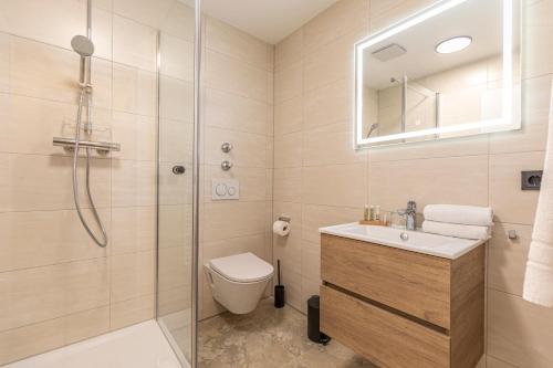 a bathroom with a shower and a toilet and a sink at Starzel Rooms in Alling