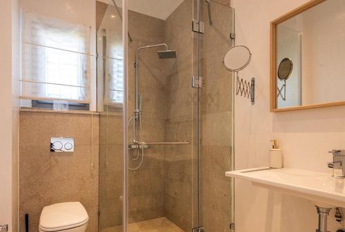 a bathroom with a shower and a toilet and a sink at Borderline in Al Matlīn