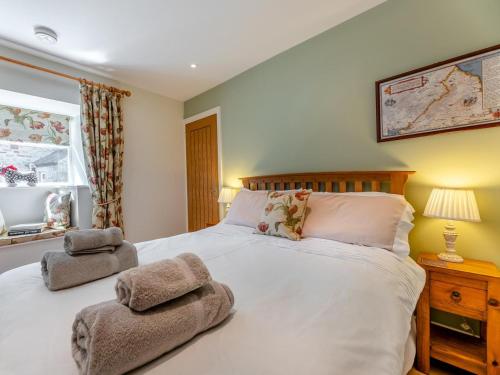 a bedroom with a white bed with two towels on it at 3 Bed in Hexham oc-96038 in Bardon Mill