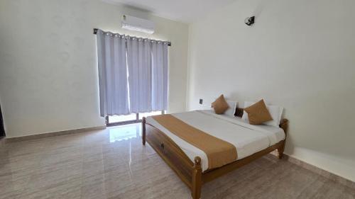 a bedroom with a bed and a large window at Noble Grand Villa in Mahabalipuram