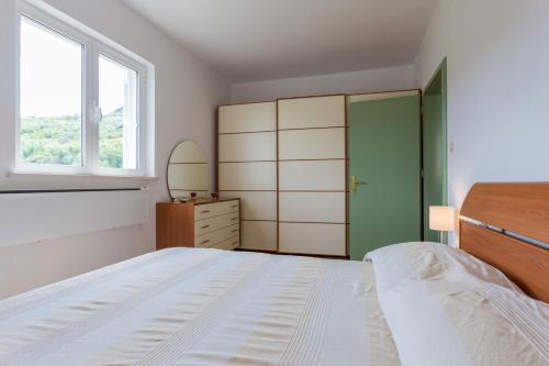 a bedroom with a bed and a dresser and a window at Villa Florence - Mediterranean GardenPool in Zaton