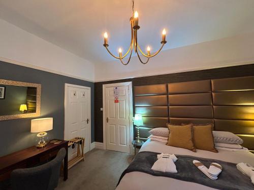 a bedroom with a large bed and a chandelier at Worth House in Cambridge