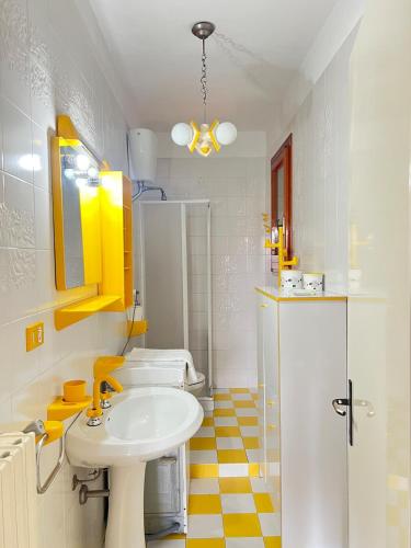 a bathroom with a white sink and a yellow checkered floor at Dimora Maffi in Metaponto