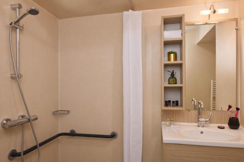 a bathroom with a shower and a sink at Quality Aparthotel Parc Marne la Vallée in Bailly-Romainvilliers
