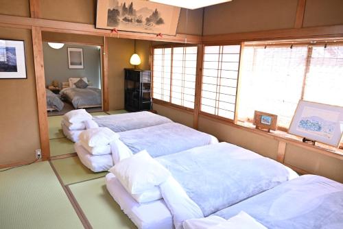 a room with two beds and chairs in it at Zen House - Tajimi in Tajimi
