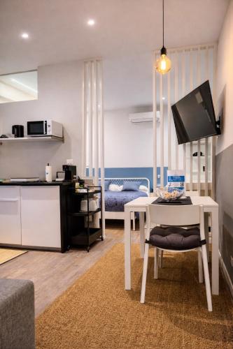 a living room with a white table and a kitchen at Suite Apartments - Corso51 in Rimini