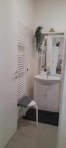 a bathroom with a sink and a mirror and a bench at Cristel malpensa room in Cardano al Campo