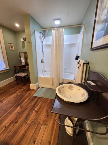 a bathroom with a shower and a table with a chair at Langdon Hill House in Gettysburg