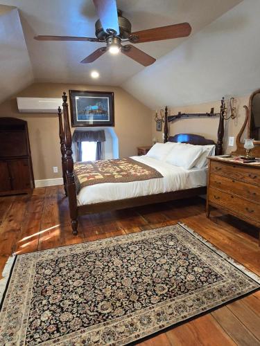 a bedroom with a bed with a ceiling fan and a rug at Langdon Hill House in Gettysburg