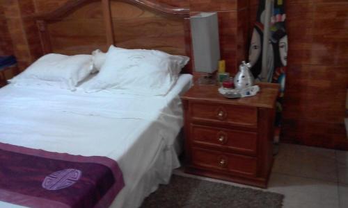 a bedroom with a bed and a night stand at Casa Blanca Tu Casa in Santa Ana