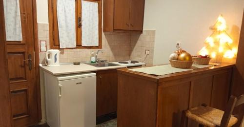 a kitchen with a white refrigerator and a christmas tree at Goura Guesthouse Lake Doxa Mountain Retreats in Goura