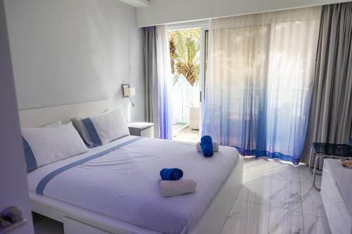 a bedroom with a bed with blue towels on it at Nautica Luxe Beachfront in Oroklini