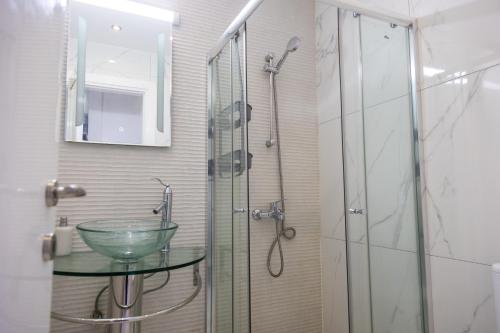 a bathroom with a glass shower with a glass sink at Nautica Luxe Beachfront in Oroklini