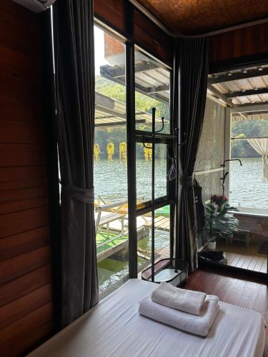 a bedroom with a window with towels on a bed at Erawan Mountain Beach & Maya Erawan & Goodview Erawan in Tha Kradan