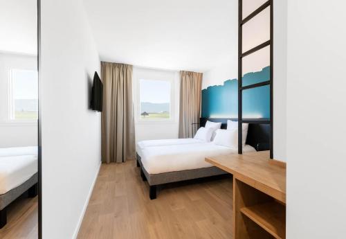 a hotel room with a bed and a desk at B&B HOTEL Nyon in Nyon