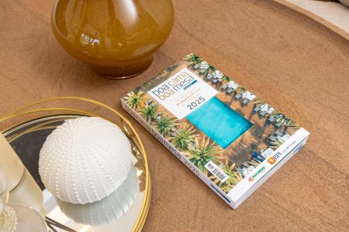 a table topped with a golf ball and a magazine at Alojamento Costa Alentejana in Zambujeira do Mar