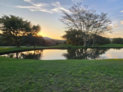 a pond on a golf course at sunset at Kruger park lodge 503 in Hazyview