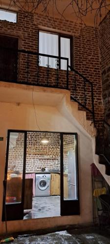ein Zimmer mit einer Treppe und ein Gebäude mit einem Fenster in der Unterkunft Ava House Taş Oda 1 in Diyarbakır