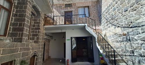 ein Backsteingebäude mit einer Tür und einem Balkon in der Unterkunft Ava House Taş Oda 1 in Diyarbakır