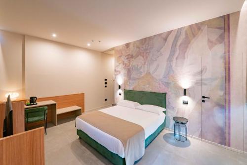 a bedroom with a bed and a desk and a wall at Lamal Hotel Napoli in Naples