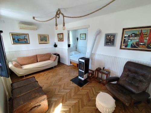 a living room with a couch and a chair at Paloznak Retrospektív in Paloznak
