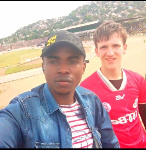 two young men standing next to each other on a beach at Explore Rock city Mwanza in Mahango