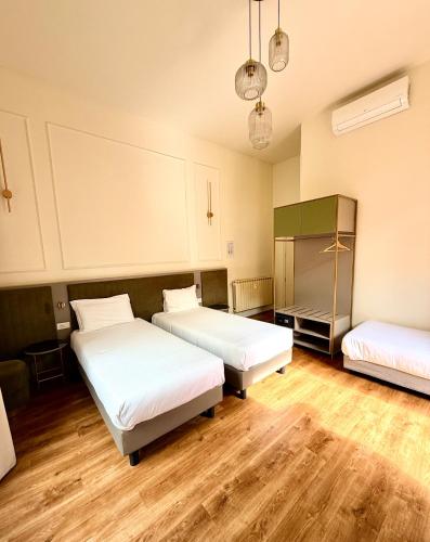 a room with two beds and a refrigerator at Hotel Duca D'Aosta in Florence